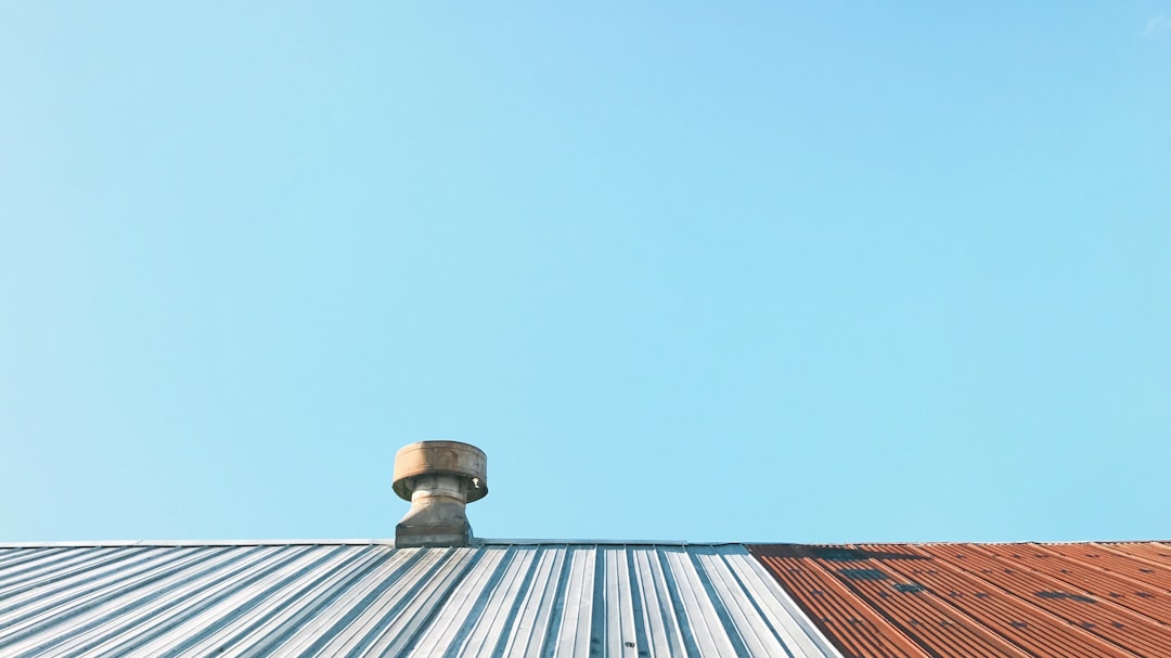 Metal Roof with Vent Stack Metal roof with silver and reddish-brown panels and a vent stack