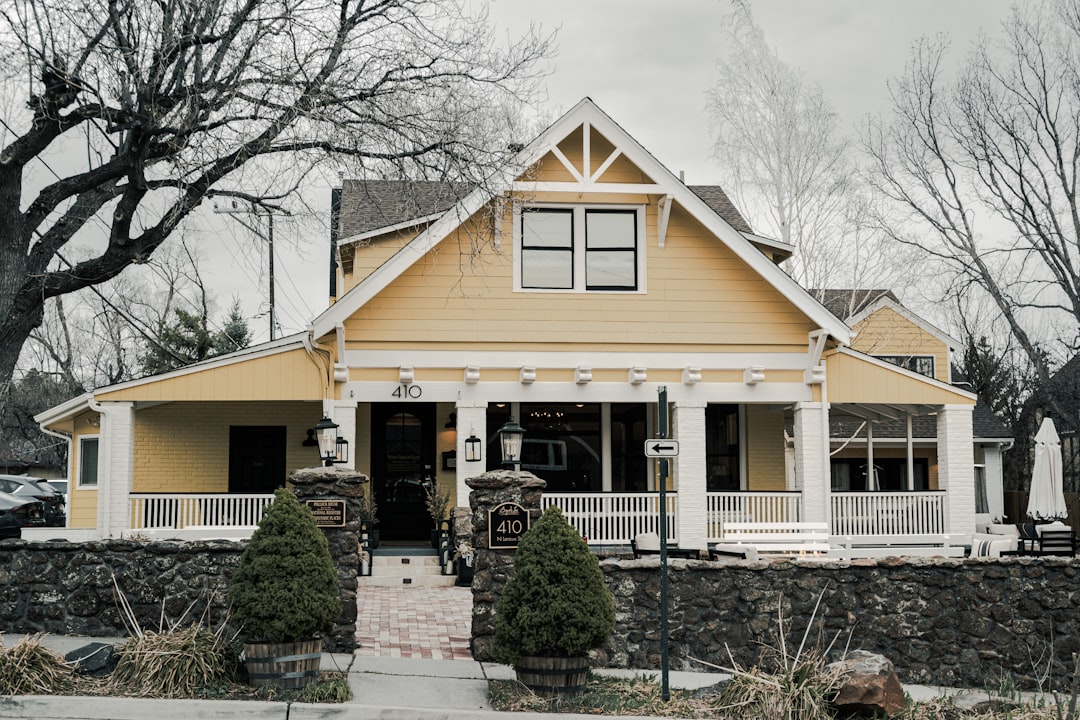 Residential Property with Porch A charming yellow house with a large porch.