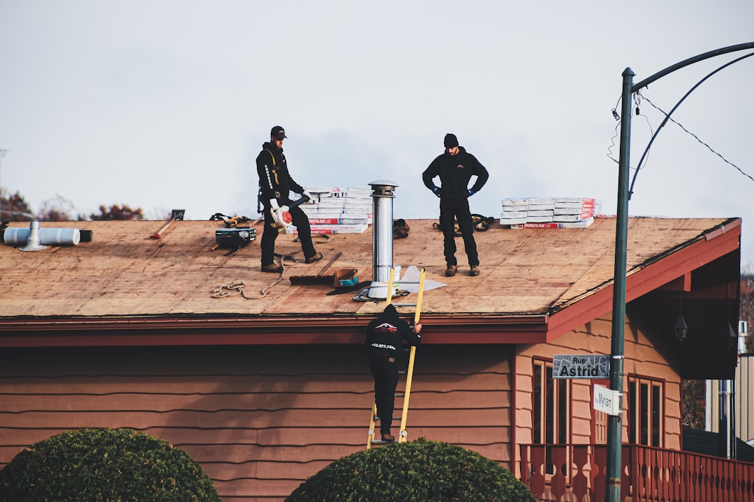 Roof Work at Brown Building a couple of men standing on top of a roof