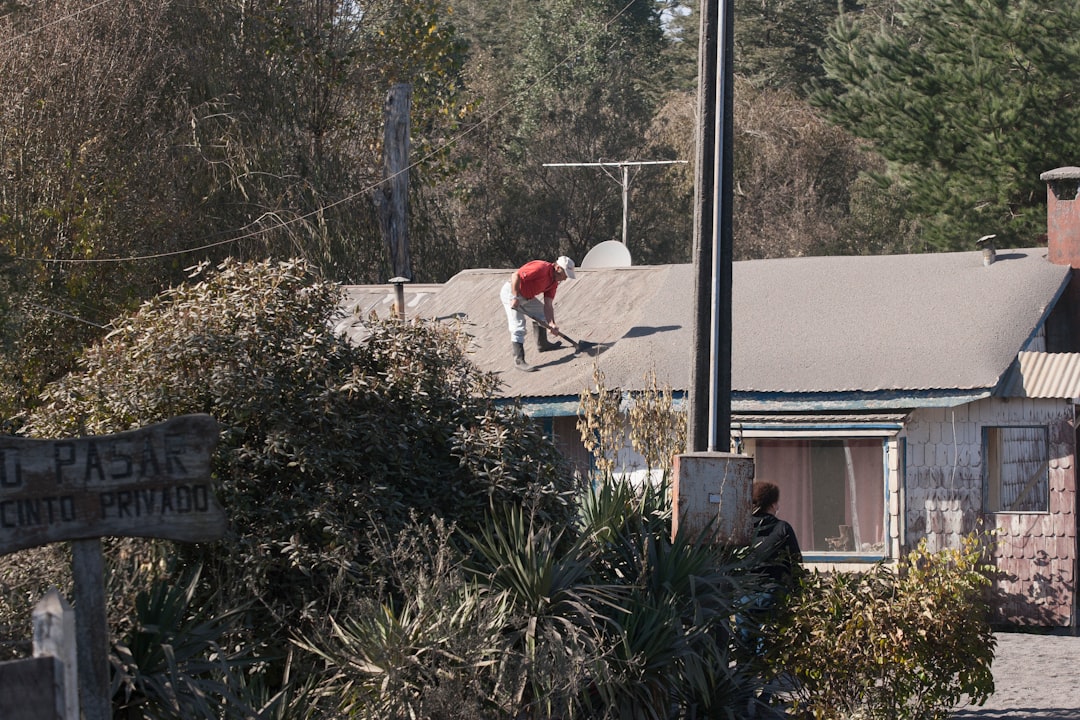 Roof Work by Kincaide Roofing A person works on a roof in a rural setting.