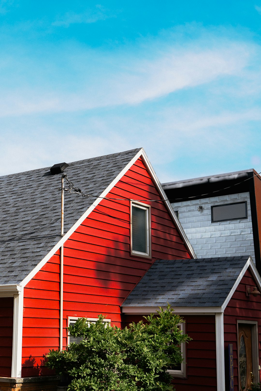 A vibrant red house under a clear blue sky.