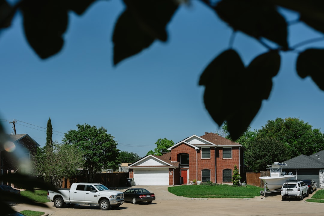 Suburban Neighborhood Scene Brick house with cars in the driveway.