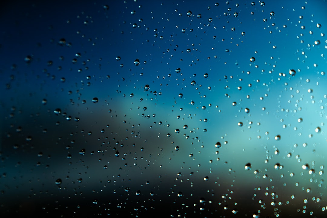 Raindrops on Glass Raindrops on glass with a blurred blue and dark background.