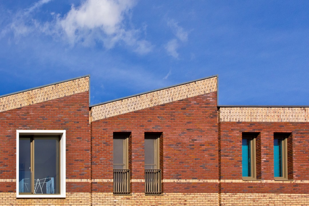 Modern brick building with sharp rooflines under blue sky.