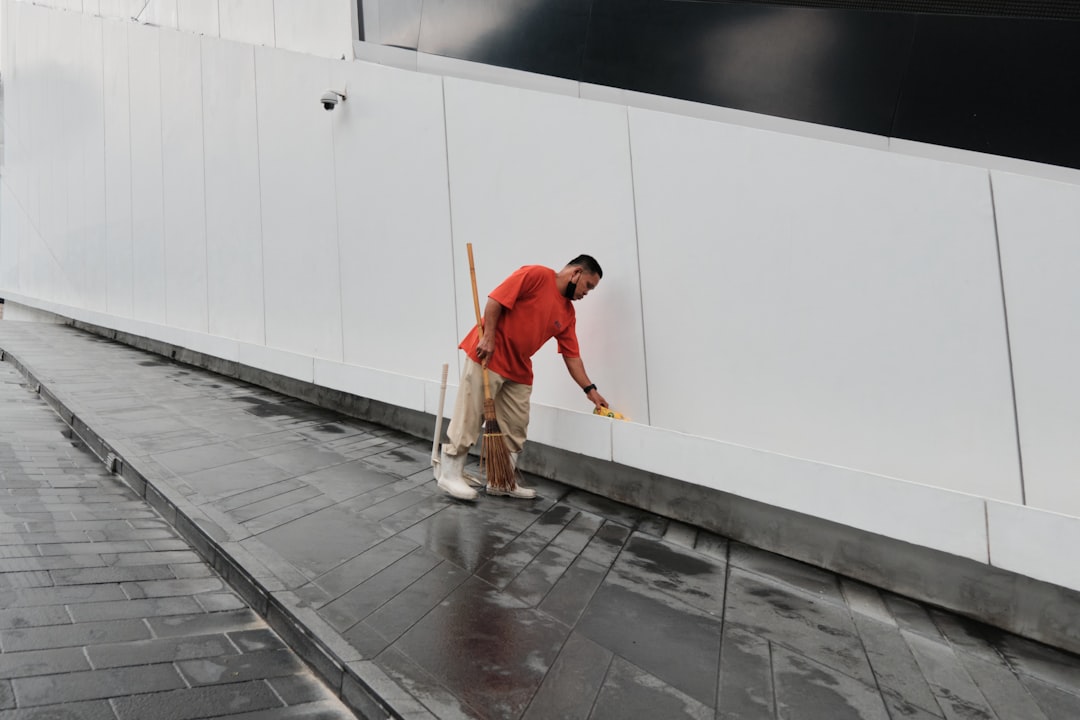 Worker Cleaning Exterior Wall a man walking on a sidewalk