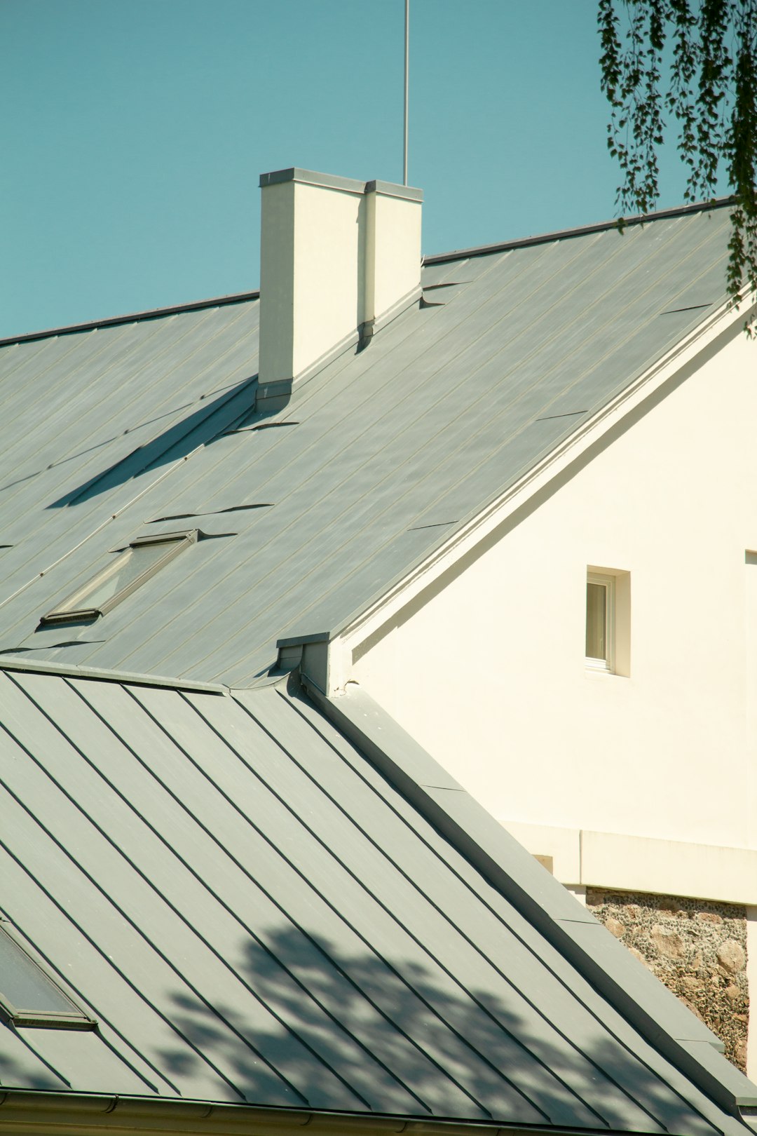 White House with Metal Roof a white house with a metal roof and two chimneys