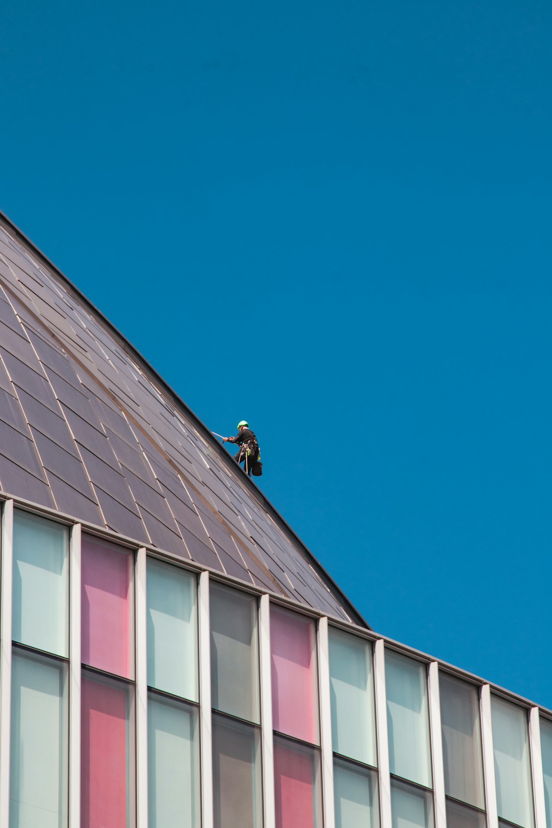 Roof Work on Modern Building a man on a roof working on the roof of a building