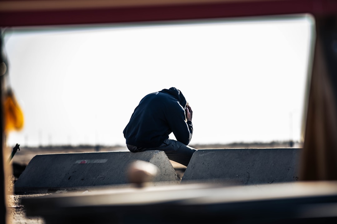 a man sitting on top of a skateboard ramp