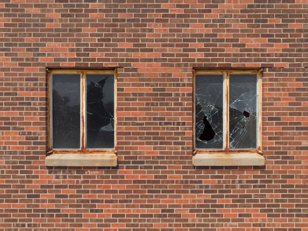 Broken Windows on Brick Wall two broken glass building windows