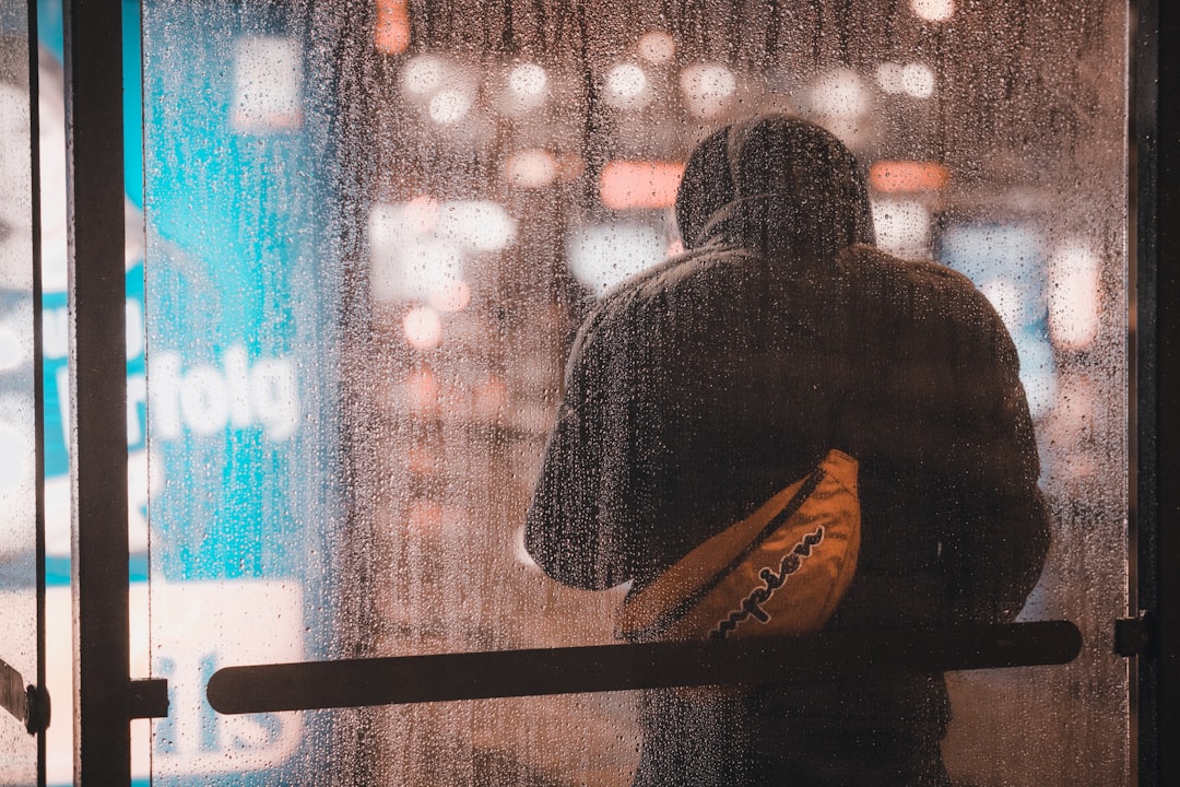 a man standing in front of a window holding a yellow bag