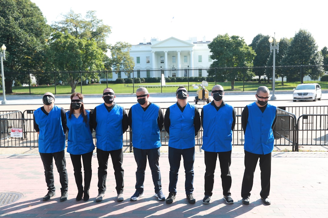 group of men in blue and white uniform standing on gray concrete road during daytime