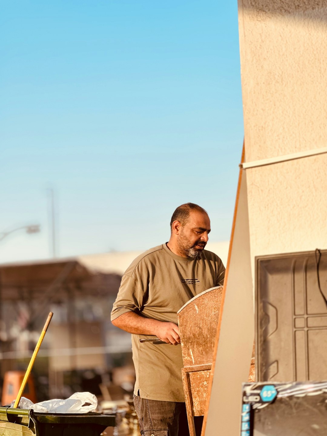 Worker Handling Roofing Panel A man works outdoors.