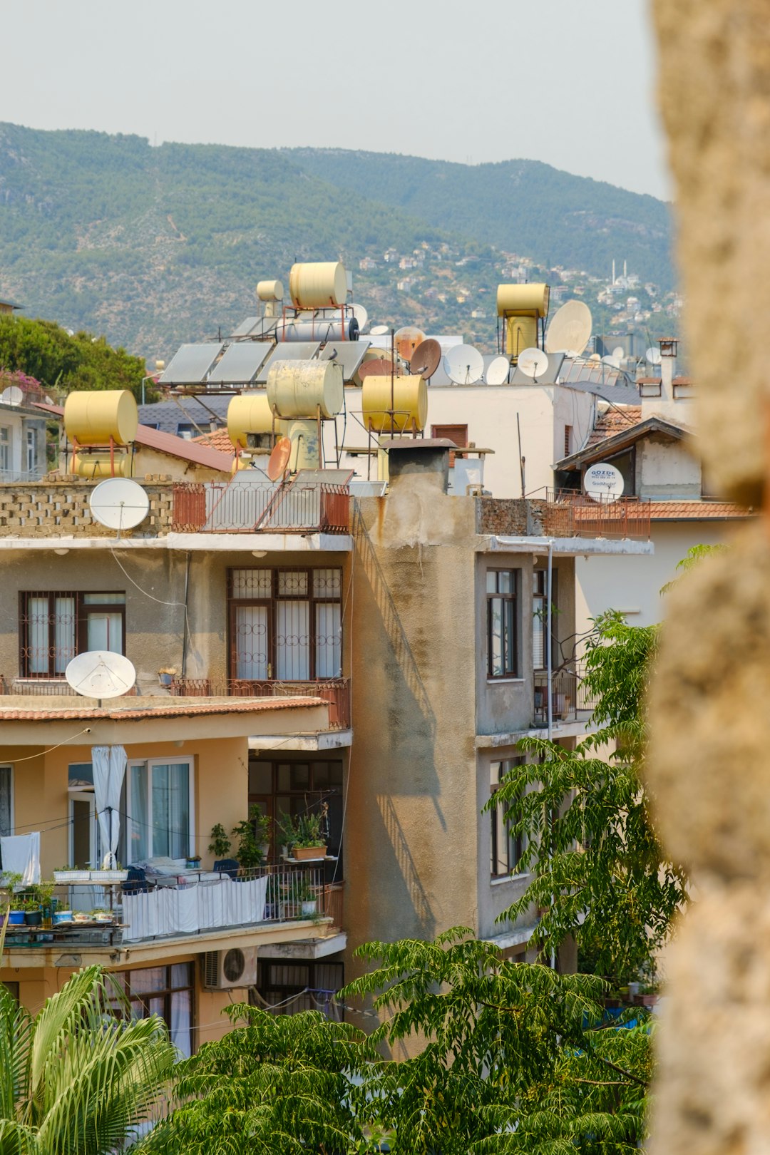 06ebd14cc48f41ba87cfac5487c455ff Urban buildings with rooftop solar heaters and satellite dishes.