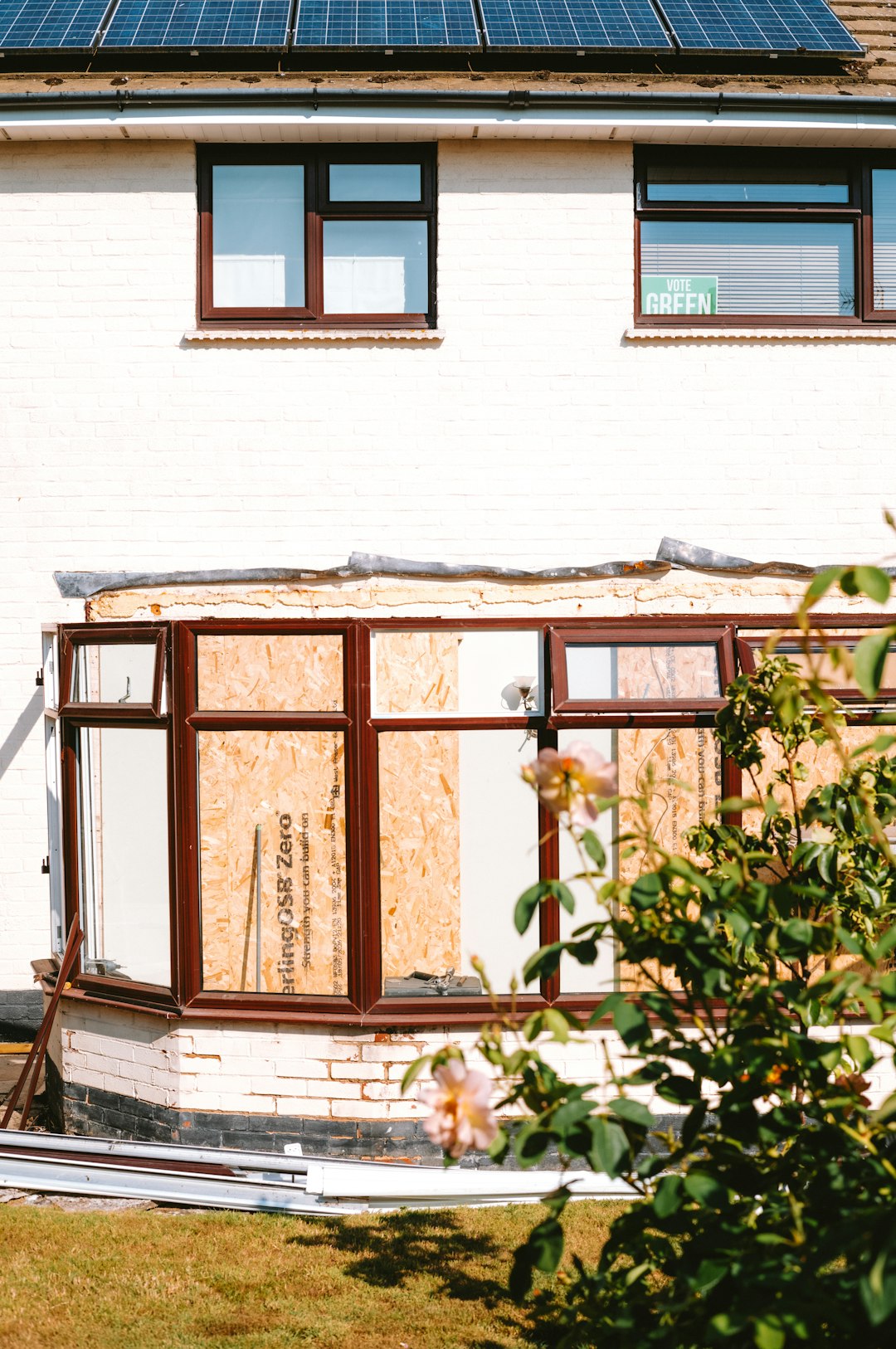 House with boarded-up conservatory and solar panels