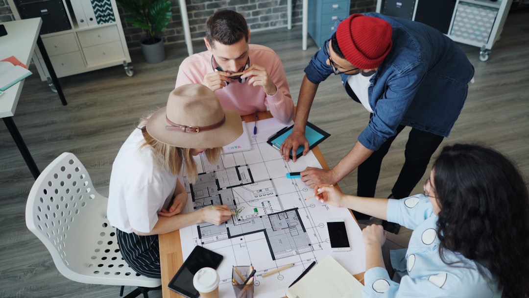 0bd7b44fc9424c308fd19b3d0582cc1b a group of people sitting around a table working on a project