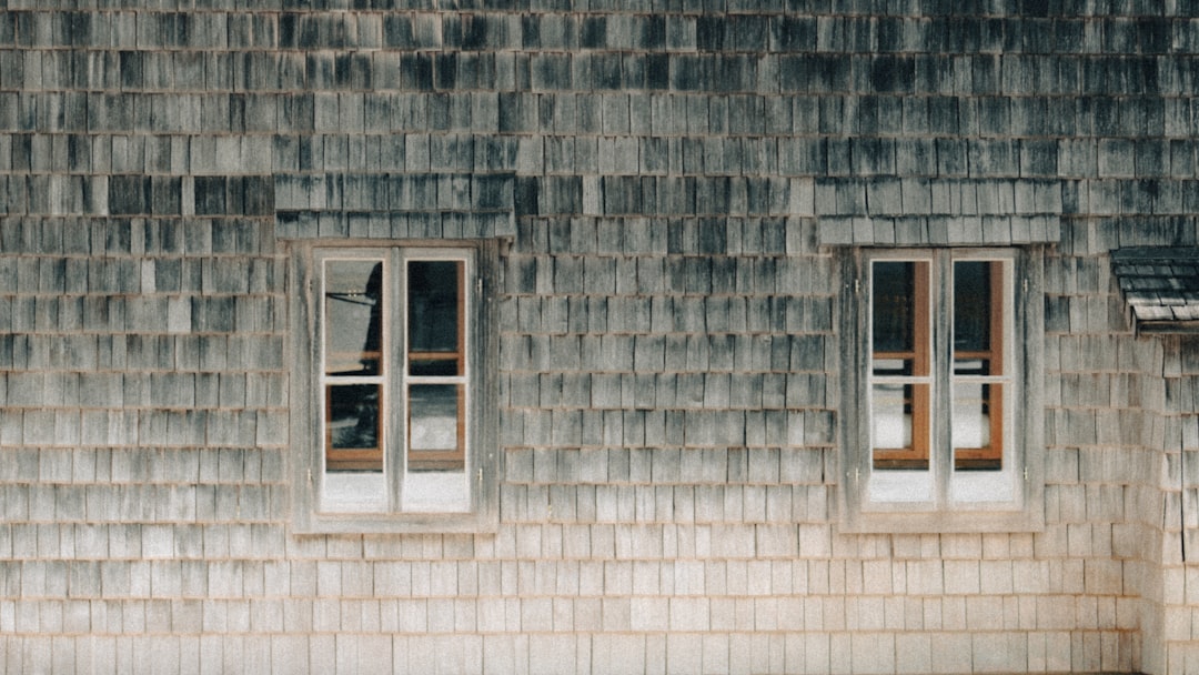 Two windows on a weathered grey shingle wall