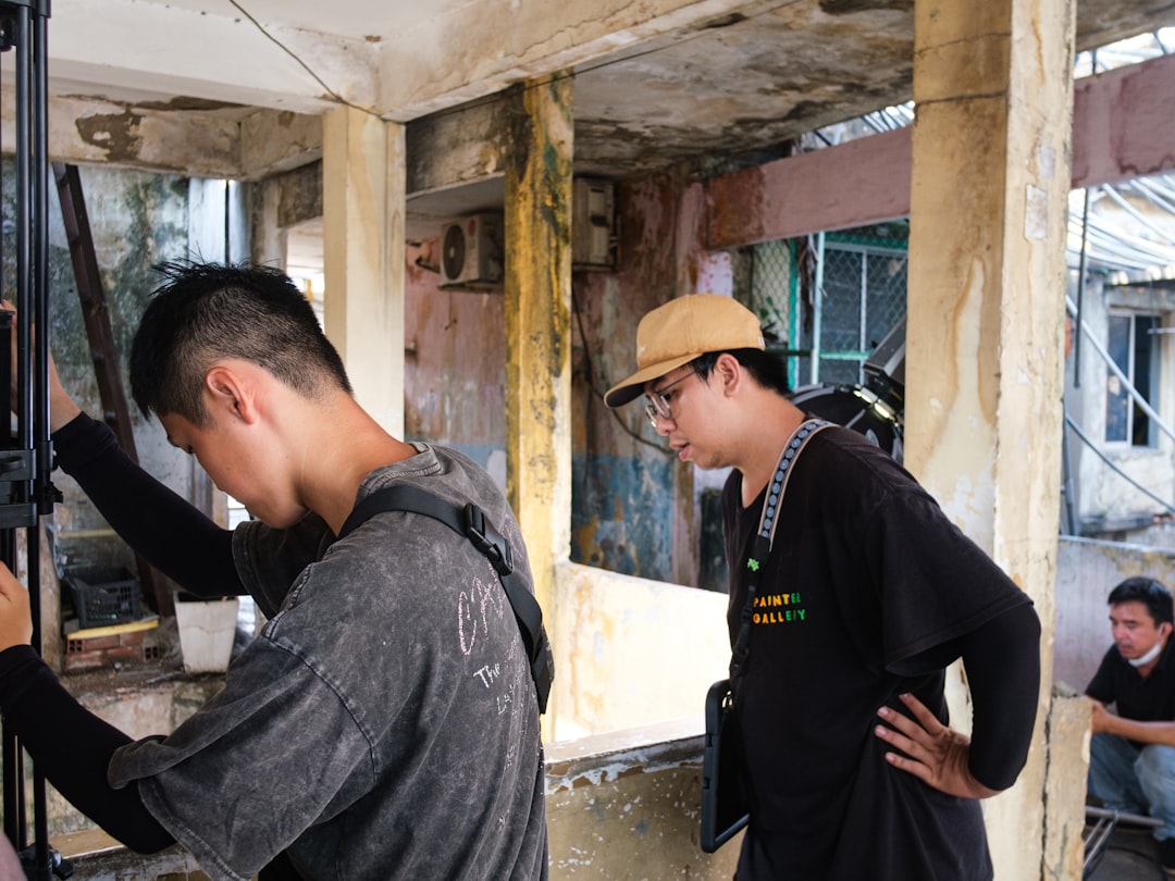 1a6d170cf4194fb5a9a29e5aca49379d Two men observing an old, dilapidated urban building structure