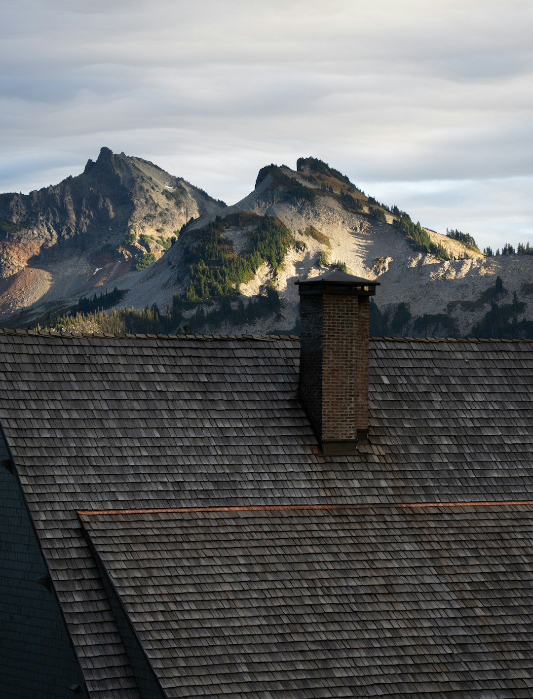 1d6edb3603254e0aaddd3dd38ab1b569 A view of a mountain range from the roof of a house