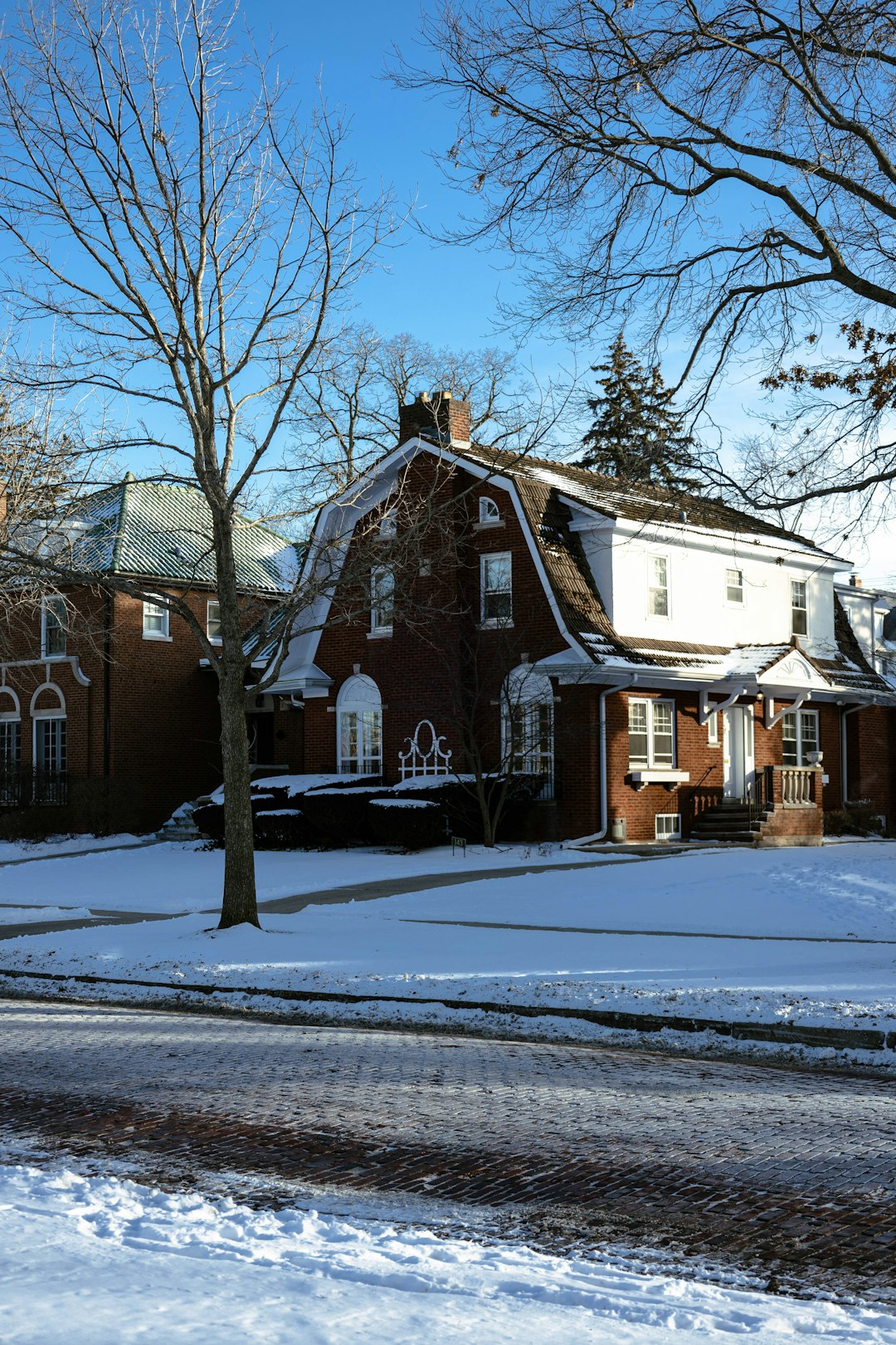 a red brick house with snow on the ground