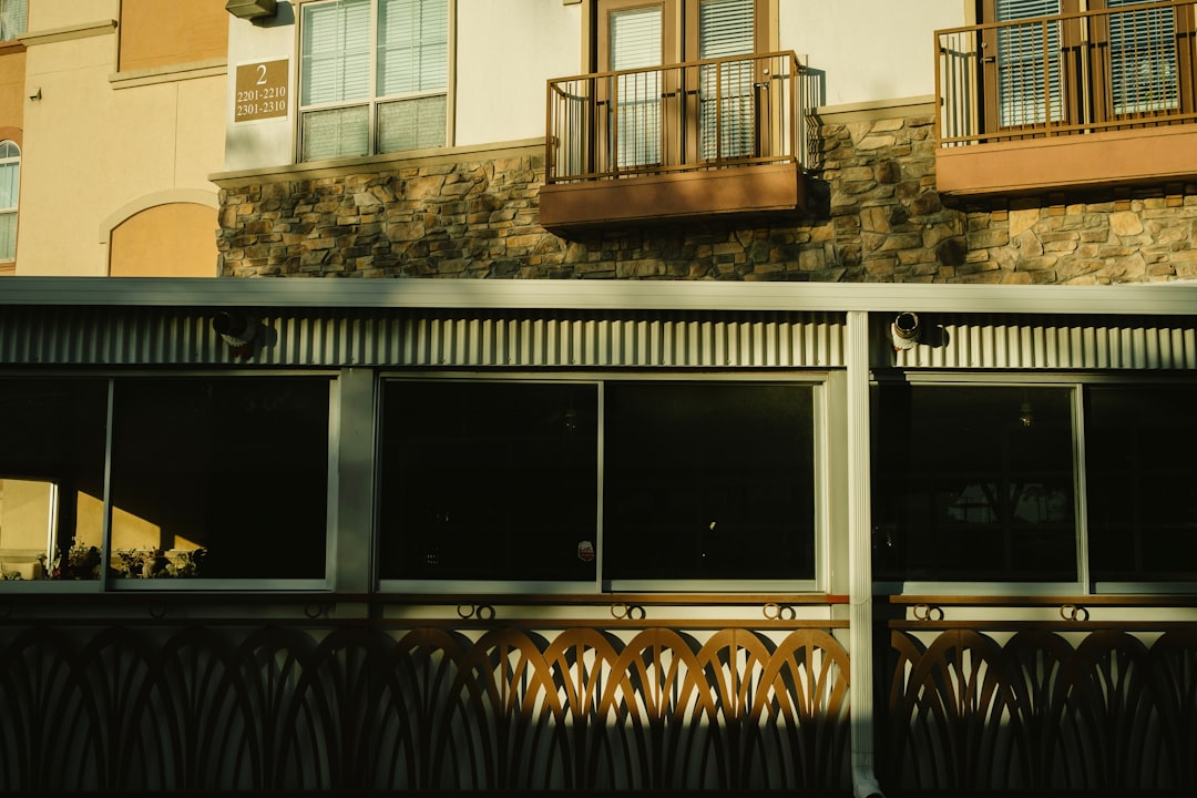 20e4430990e64ea2bc83c6639f742c1f Building exterior with large windows and decorative balcony