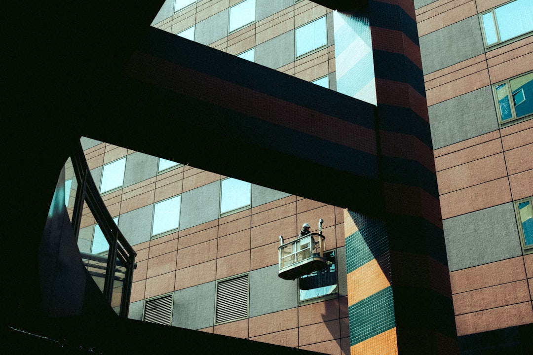 Worker cleaning windows on a modern building exterior