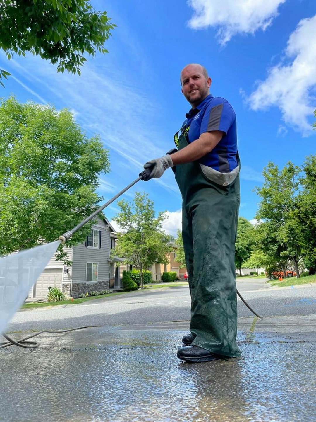 428baf78010e4f4cbeccffa416f3fe6a a man is cleaning the street with a hose