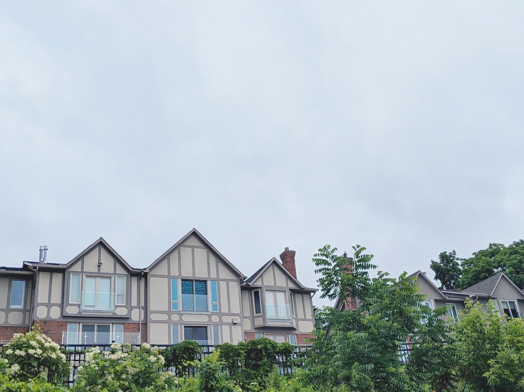 Houses and green trees under a cloudy sky.