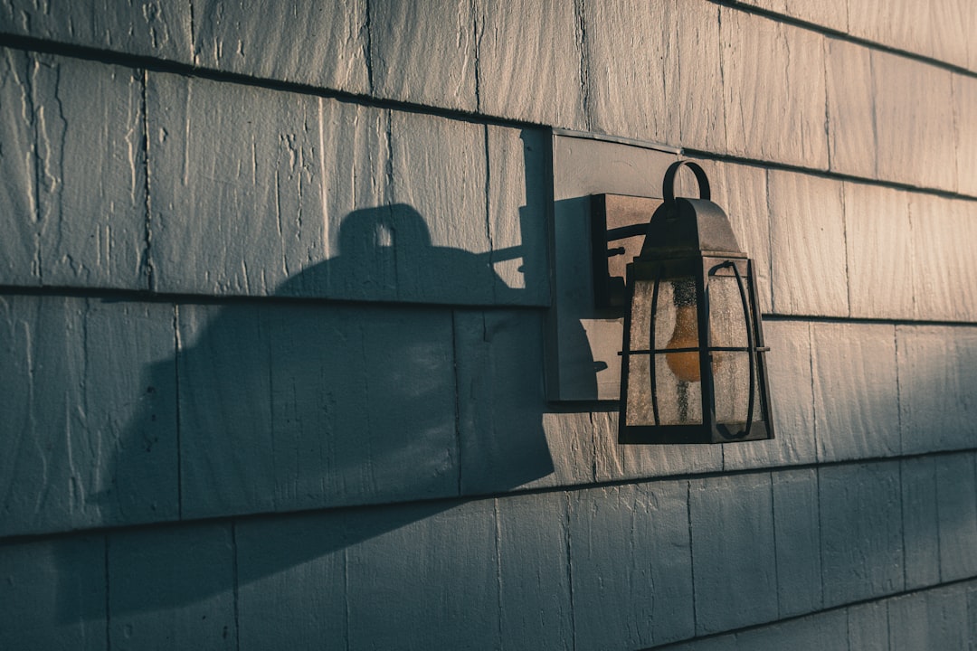 Outdoor Lantern on Clapboard Wall Outdoor lantern casts a shadow on a clapboard wall.