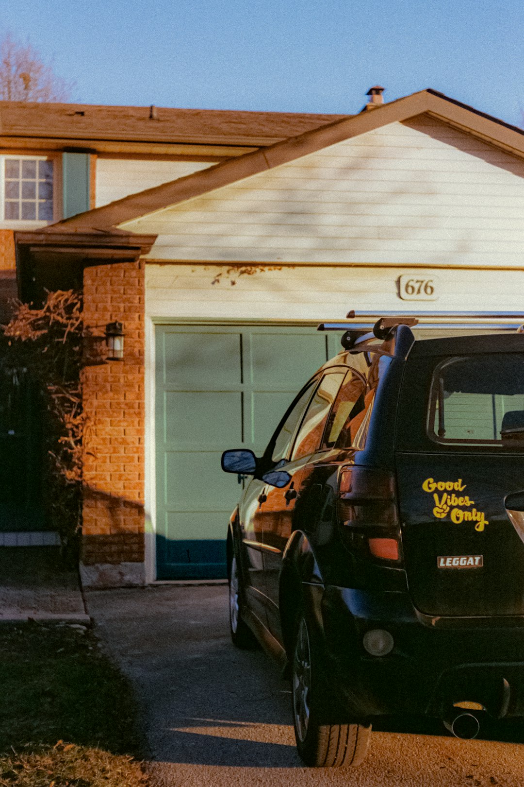 4fe0692e6b004739bdbe20a14f4c618f Black car parked in front of a suburban house.