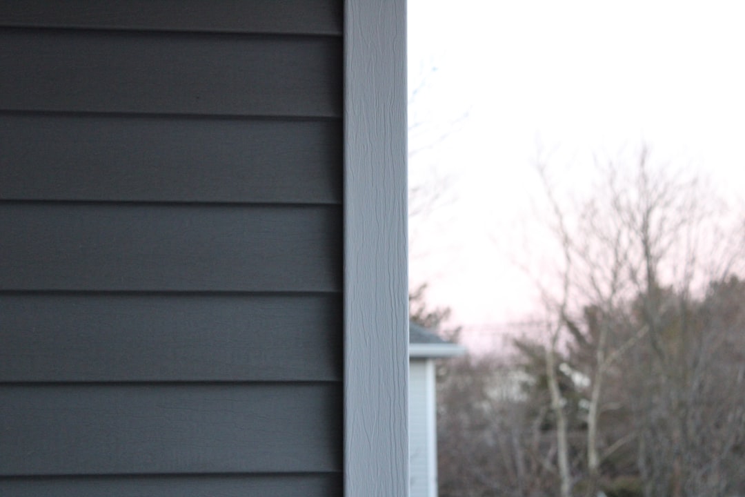 Residential Building Corner Corner of a building with dark gray siding and light-gray trim board