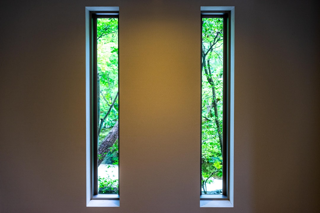 535b3d3170e64f97aa82fd11cecdd63a A room with two windows and a bench