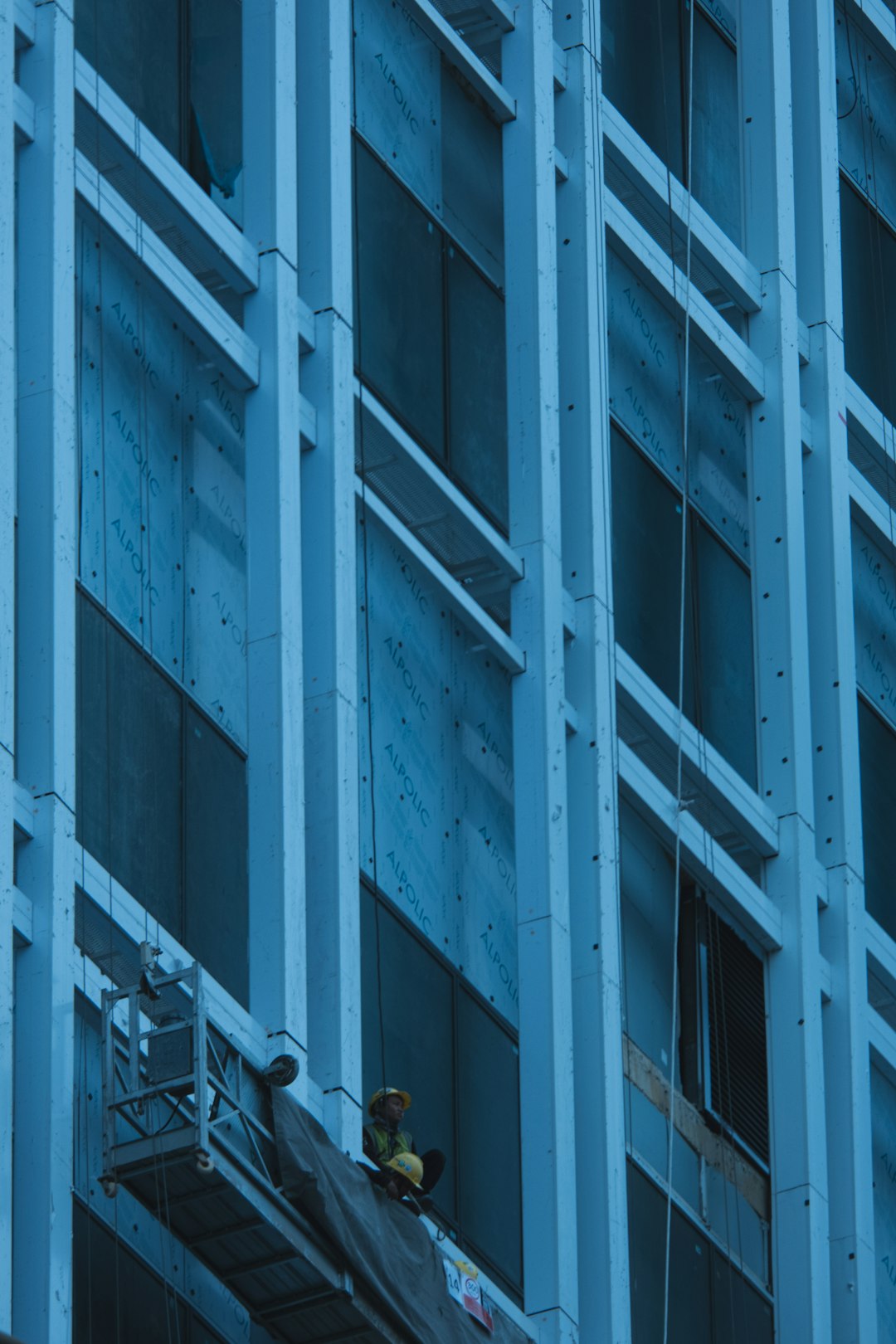 a man on a scaffold working on the side of a building