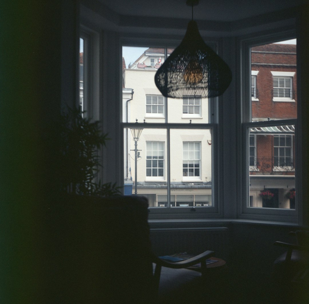 Dark room with bay window overlooking urban street