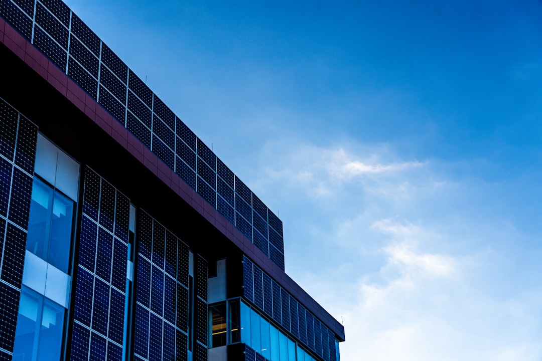 Modern building facade with solar panels against blue sky