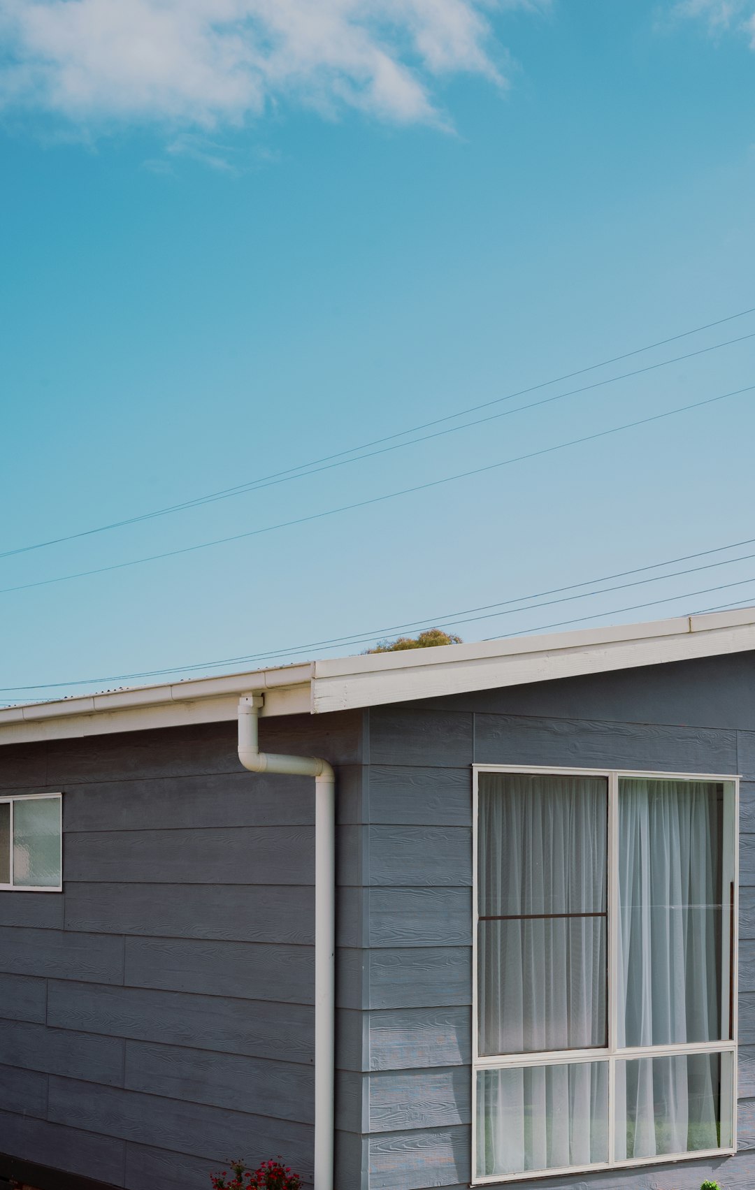 67a9eb3601ef4d2c85dc0de27f67db8c a house with a blue sky and clouds in the background
