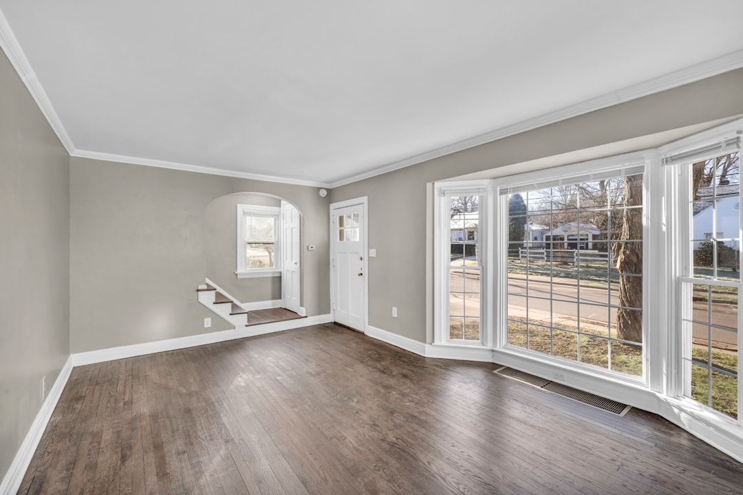Spacious empty living room with bay window, gray walls