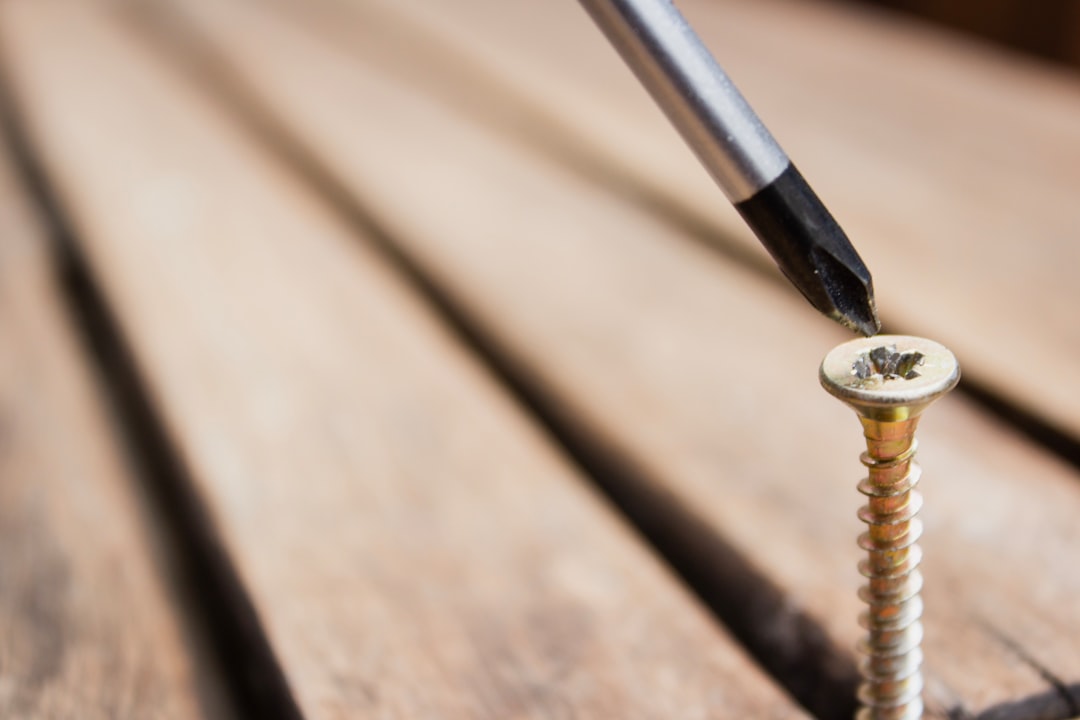 Close-up of a brass Phillips screw being driven into wood
