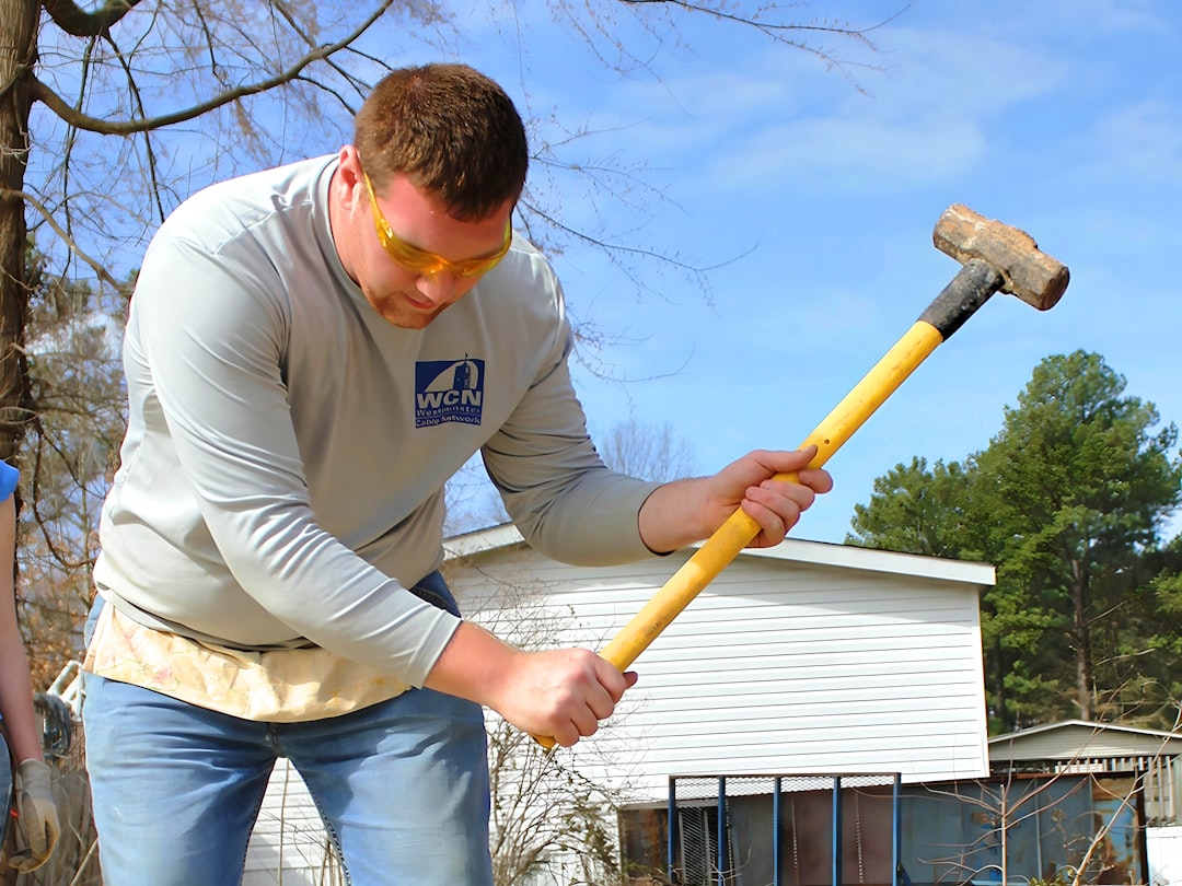 7bf8139c14cf424aa35cc83287df7384 a man holding a hammer and a large hammer