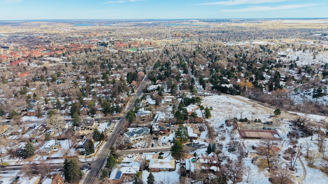 Aerial view of a snowy suburban neighborhood with trees