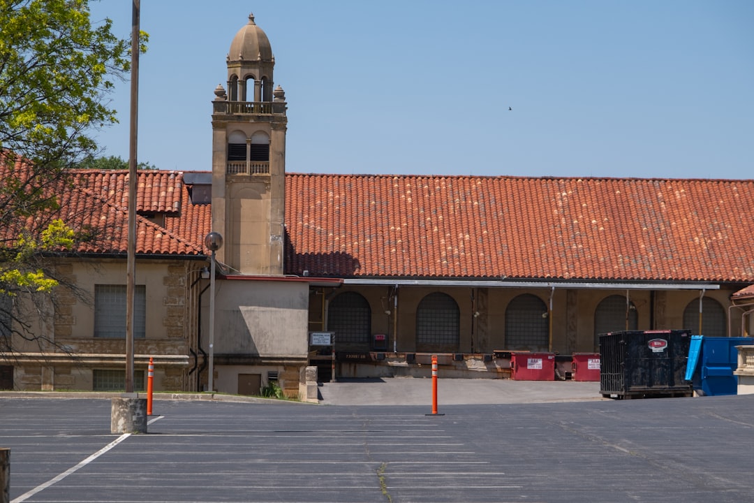 8a2a696f0a5240c68bcd3f8e8b988bed Historic building with a prominent tower and red tile roof.