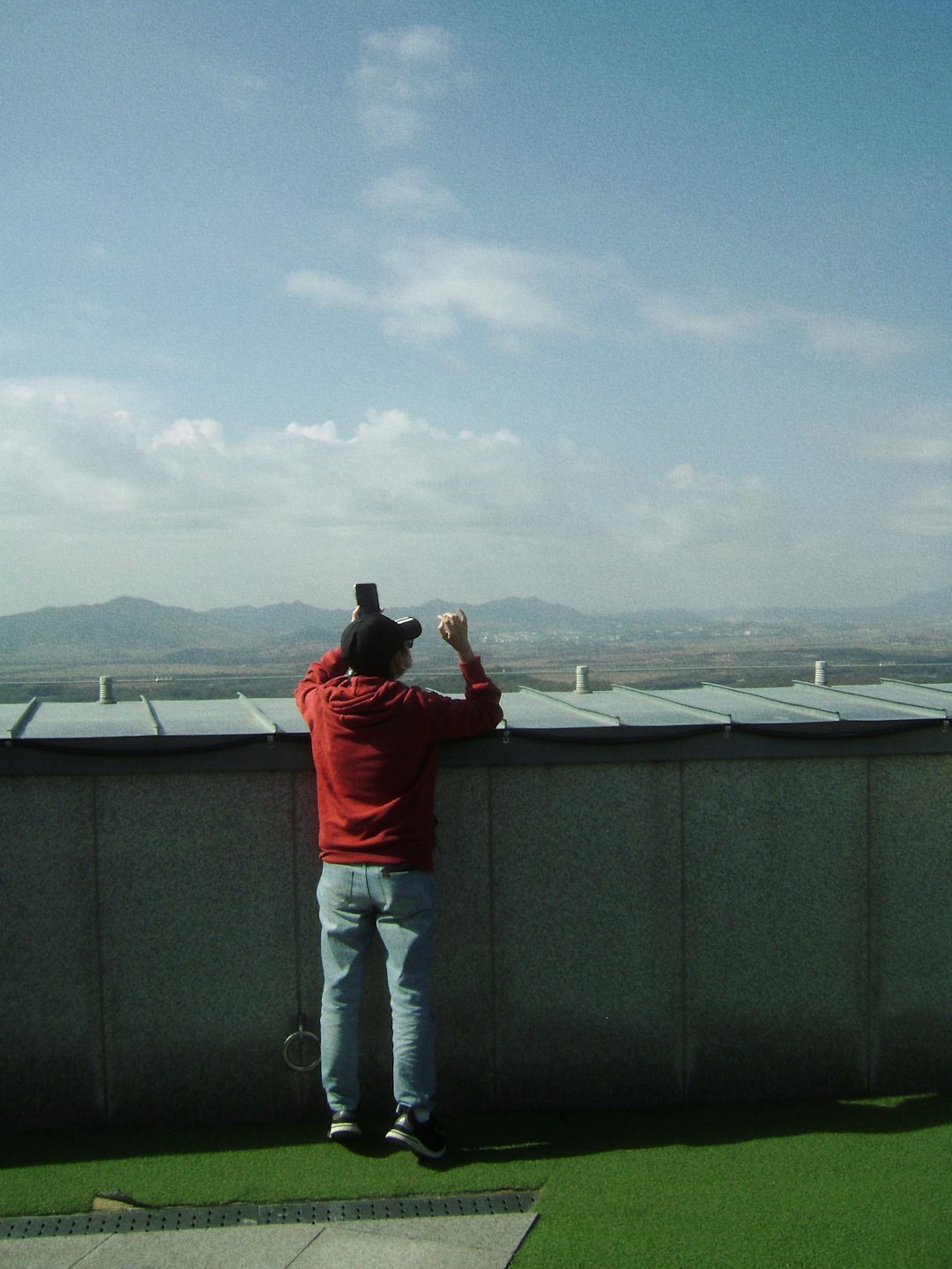 Worker on Rooftop a man standing on top of a grass covered field