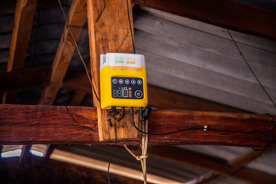 Roof Space Device Installation Yellow device mounted on wooden beam with wires