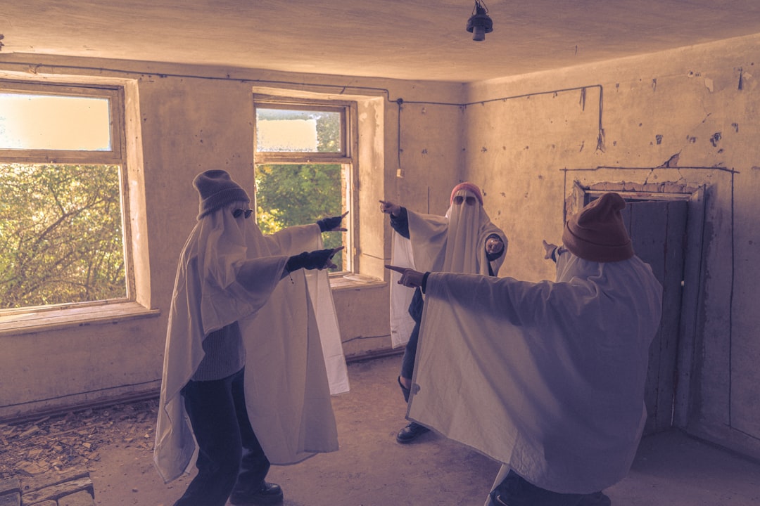 Three people in ghost costumes pointing fingers