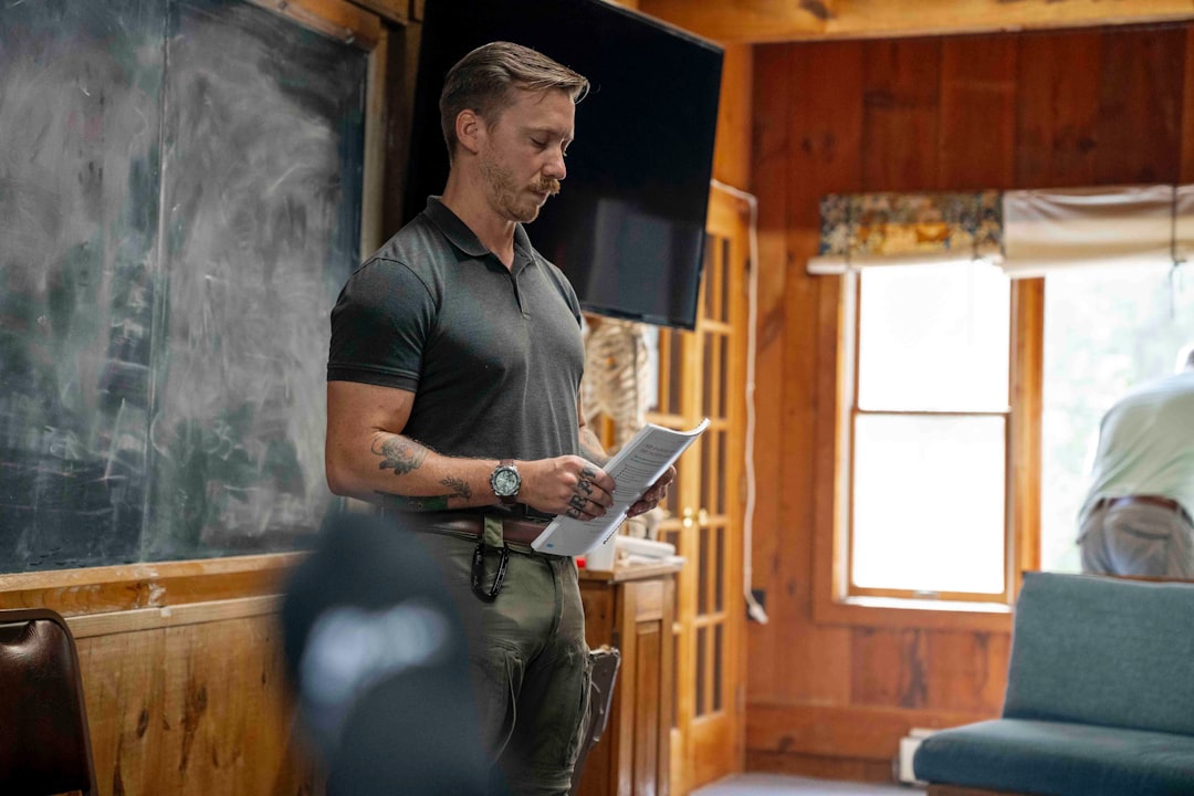 931d30f87c124a38bb7cd2140e0d8bcc Man in polo shirt reading papers in room