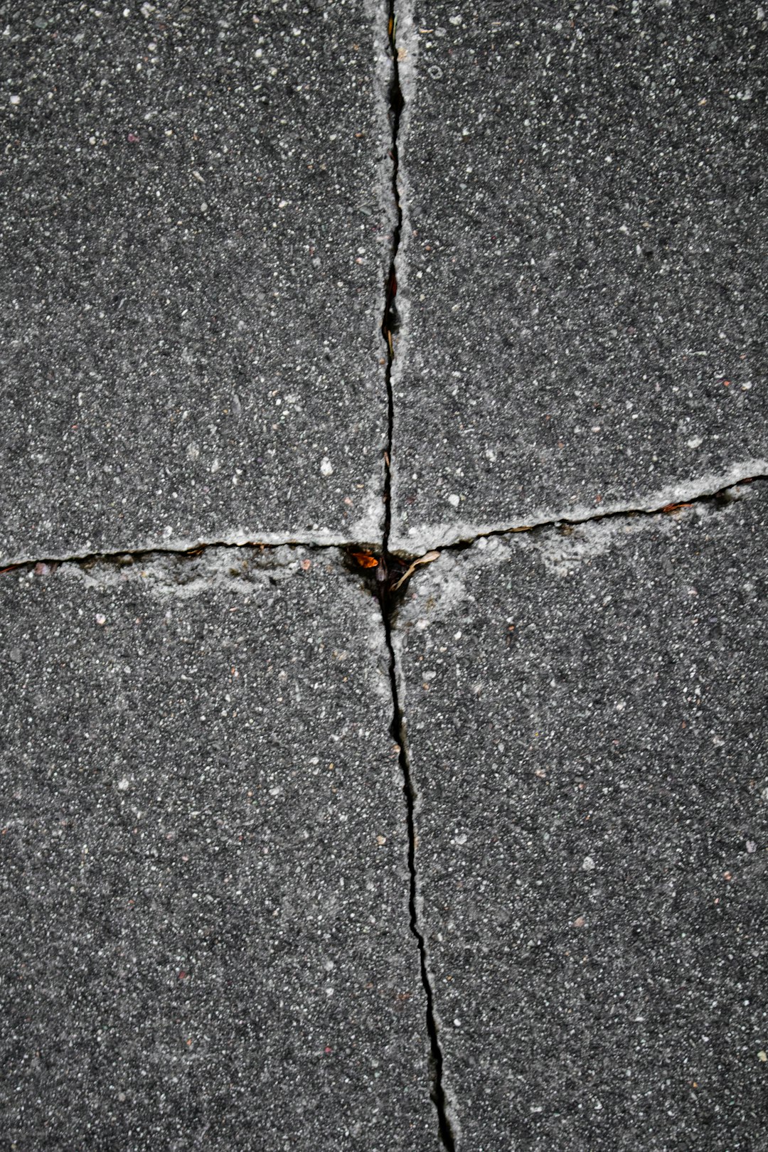 Cracked pavement forms a cross-like pattern