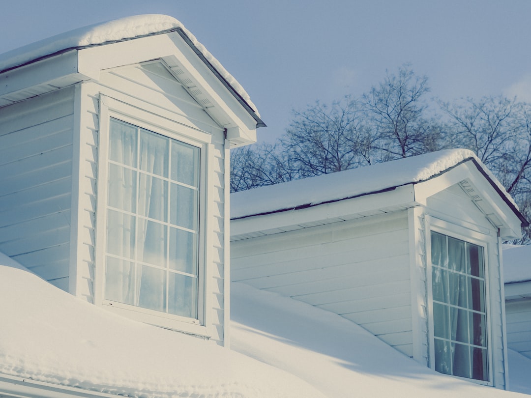 97bbe4e25c164ebea18f9976c290a7b7 A white house with a snow covered roof