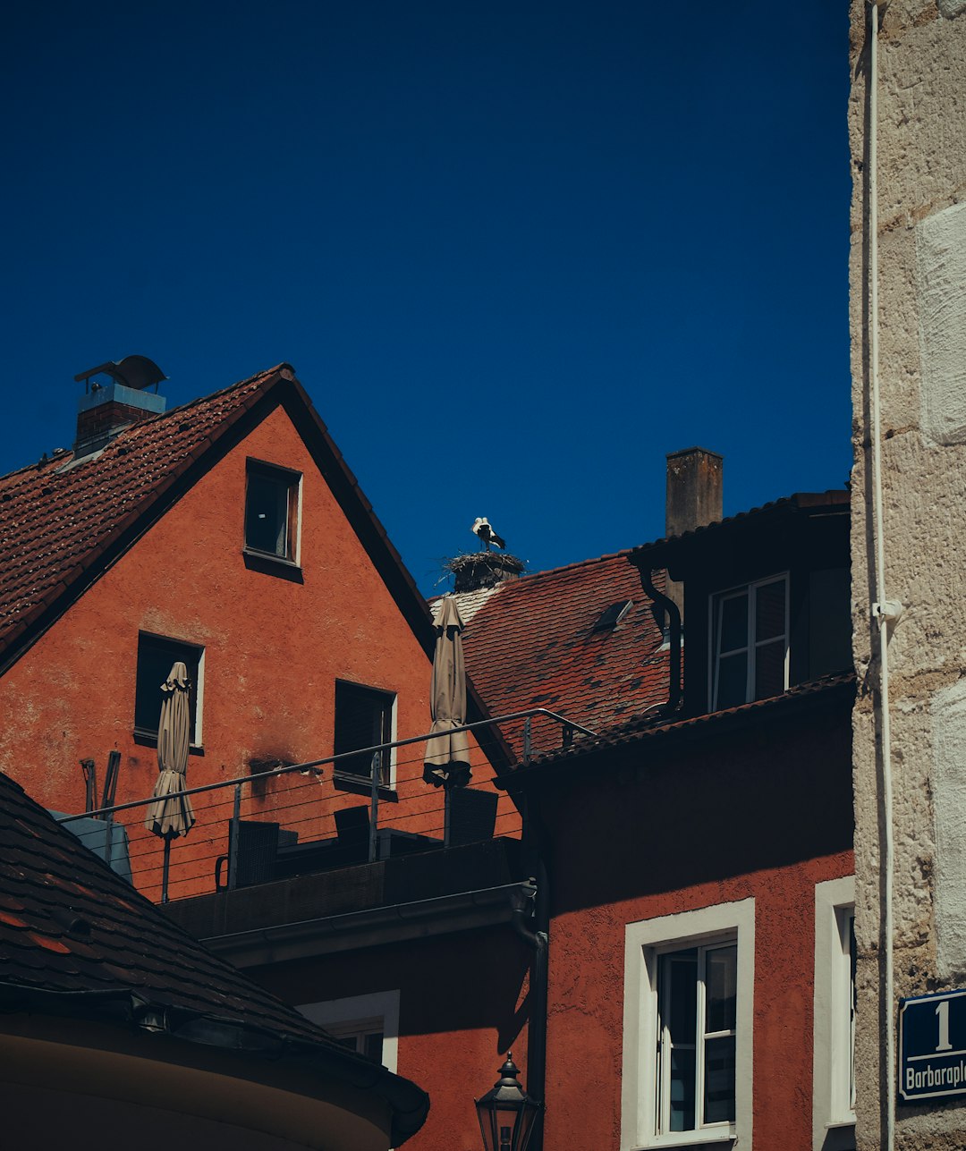 9d766254e05c45e0bc73cf6b1f09b5b0 Red buildings with tiled roofs under a clear blue sky.