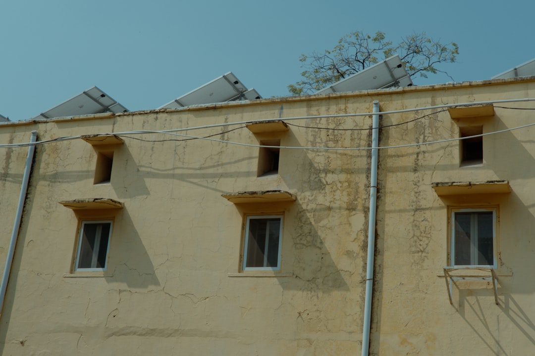 Beige building with windows and solar panels on roof.