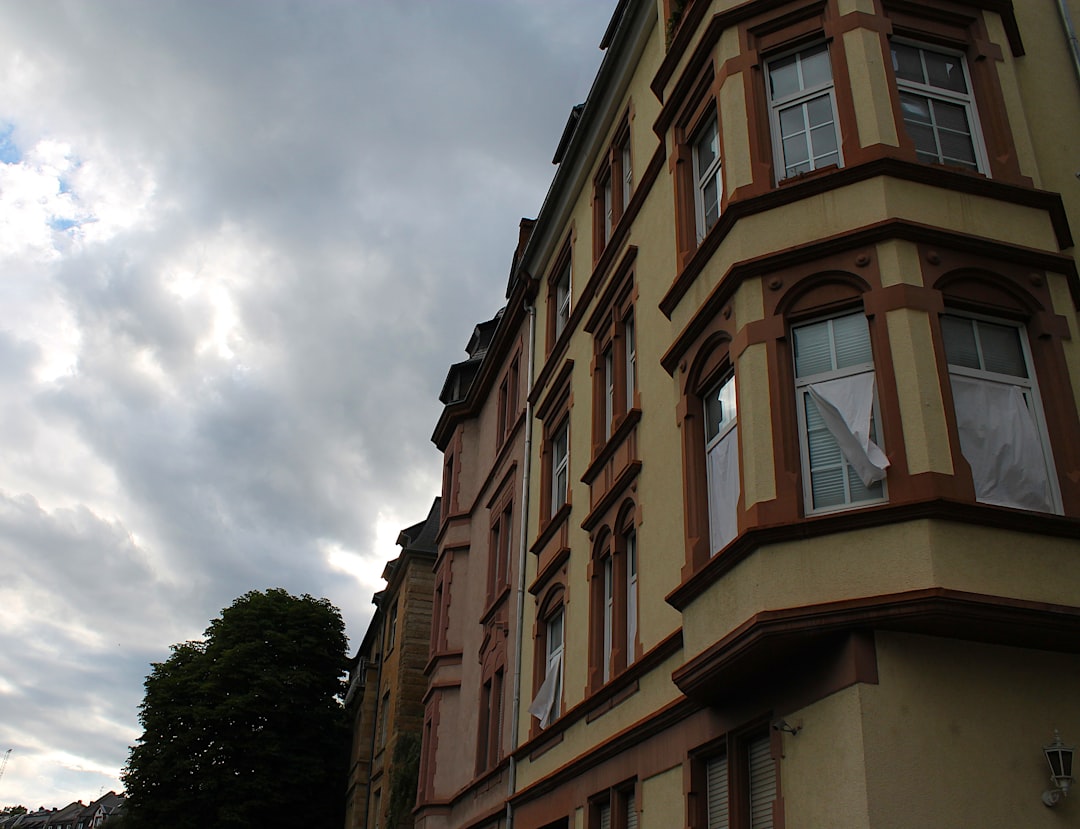 A yellow building with bay windows under a cloudy sky