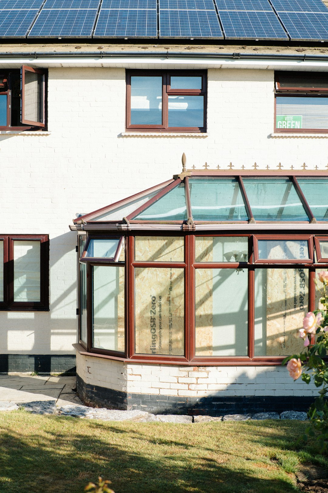 White house with solar panels and glass conservatory